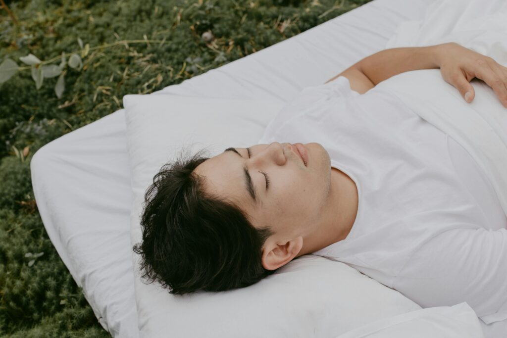 A peaceful moment of an adult resting outdoors on a pillow, embodying tranquility and comfort.